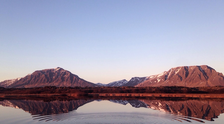 Kayaker on a lake in early spring with snow still visible on distant shoreline hills