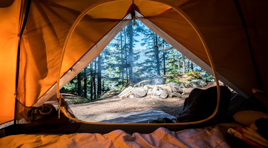 Tent pitched on a granite point beside a calm lake at sunset